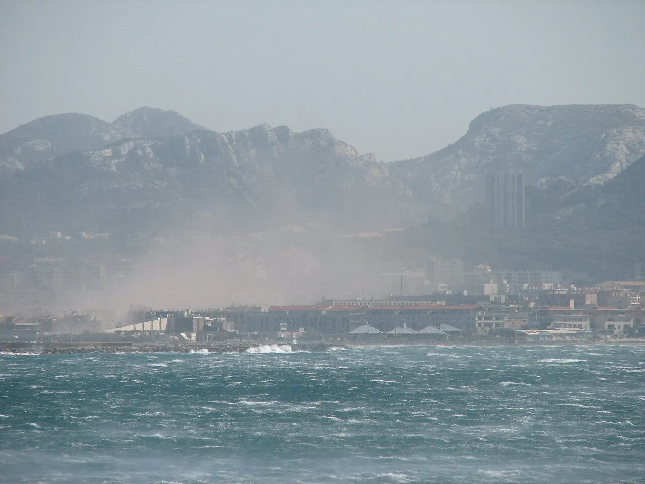Vent de mistral soufflant sur le littoral provençal sous un ciel mouvementé